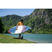 Man Carrying Aqua Marina Hyper Inflatable SUP in Front of Lake & Mountains