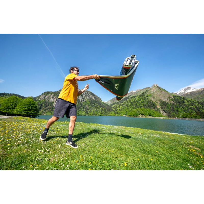 Man Unrolling Deflated Aqua Marina Hyper SUP in Front of Lake & Mountains