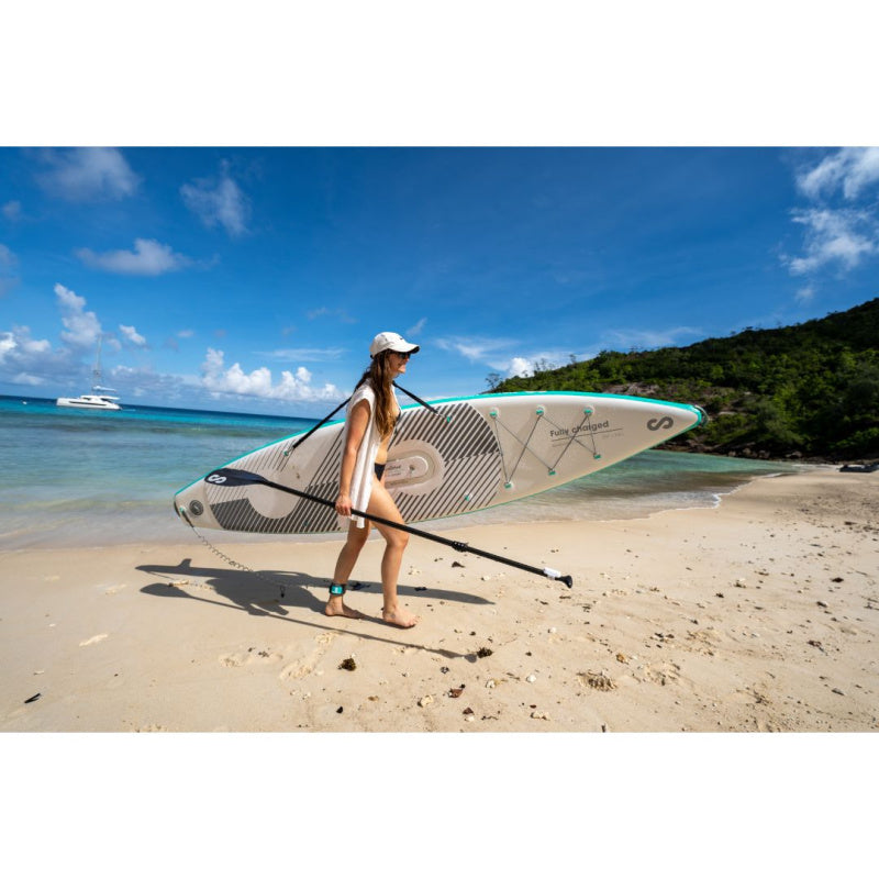 Woman Using Shoulder Strap to Carrying Sipaboards Drive Tourer Electric SUP onto Beach while Holding the Paddle 