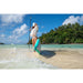Woman on Shallow Beach Holding Paddle with Sipaboards Drive Tourer Electric SUP Leaning Against Her