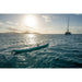 Sipaboards Drive Tourer Electric SUP in Ocean with Sailboat, Mountains, and Sun in the Background