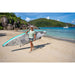 Man Using Shoulder Strap to Carry Sipaboards Drive Tourer Electric SUP on Beach While Holding the Paddle