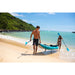 Man and Woman Carrying Spinera Hybris 410 Inflatable Kayak on Out of Water onto Beach Front View