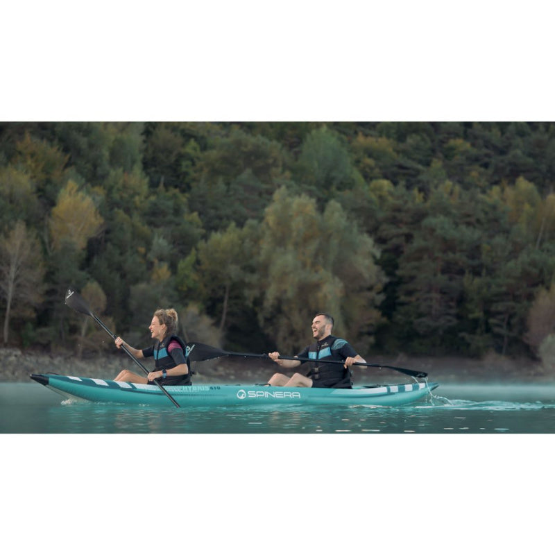 Woman and Man Paddling Spinera Hybris 410 Inflatable Kayak with Trees in Back Left Side View