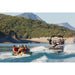 Spinera Let's Go 4 Family Towable 4 Person Tube - People Riding Tube Behind Boat on the Left